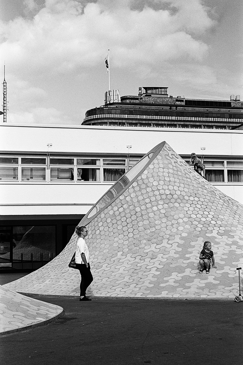 Black and white anlaog photograph of a woman eating a chocolate bar